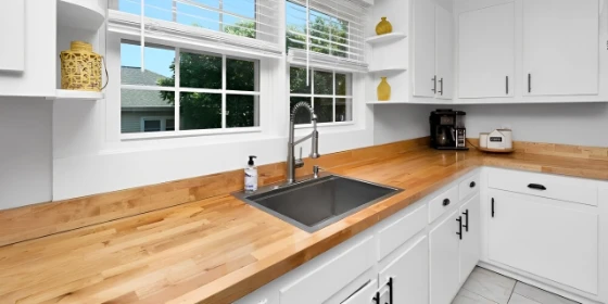 Kitchen with butcher block countertops and white cabinets