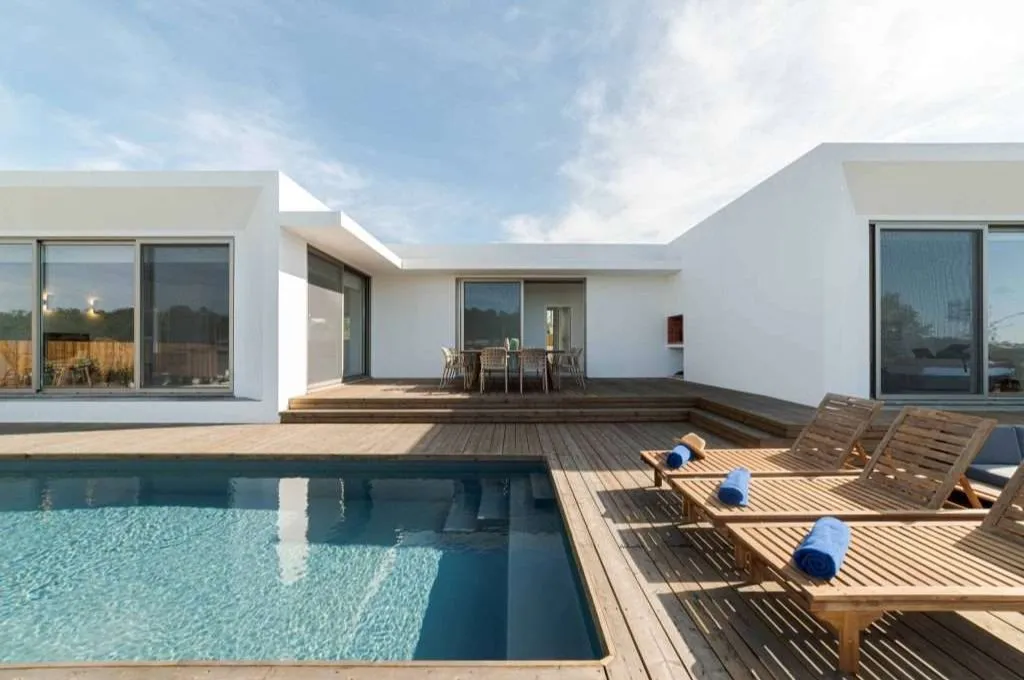 Contemporary white home with pool and wooden deck