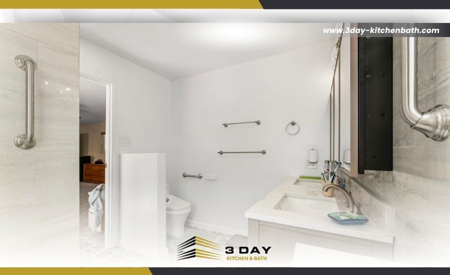 Small bathroom remodel in San Diego, CA showcasing decorative patterned floor tile, a privacy half-wall for the toilet area, brushed nickel towel bars, and accessibility grab bars.