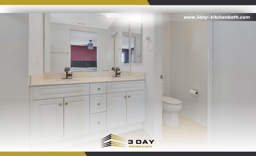 Bright bathroom remodel featuring a white double-sink vanity with dark faucets and a separate toilet area, branded by 3 Day Kitchen & Bath.