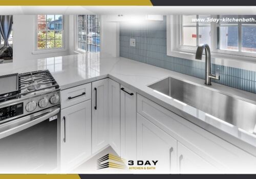 Close-up of a modern kitchen remodel featuring a large stainless steel undermount sink, light blue backsplash, and the 3 Day Kitchen & Bath logo.